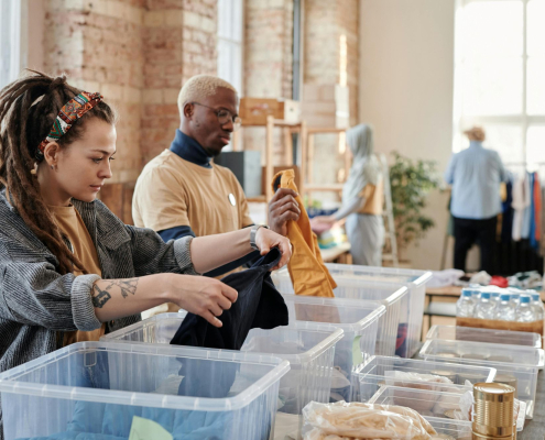 Man and a woman sorting through boxes of clothes - Neighbourly Case Study testimonial